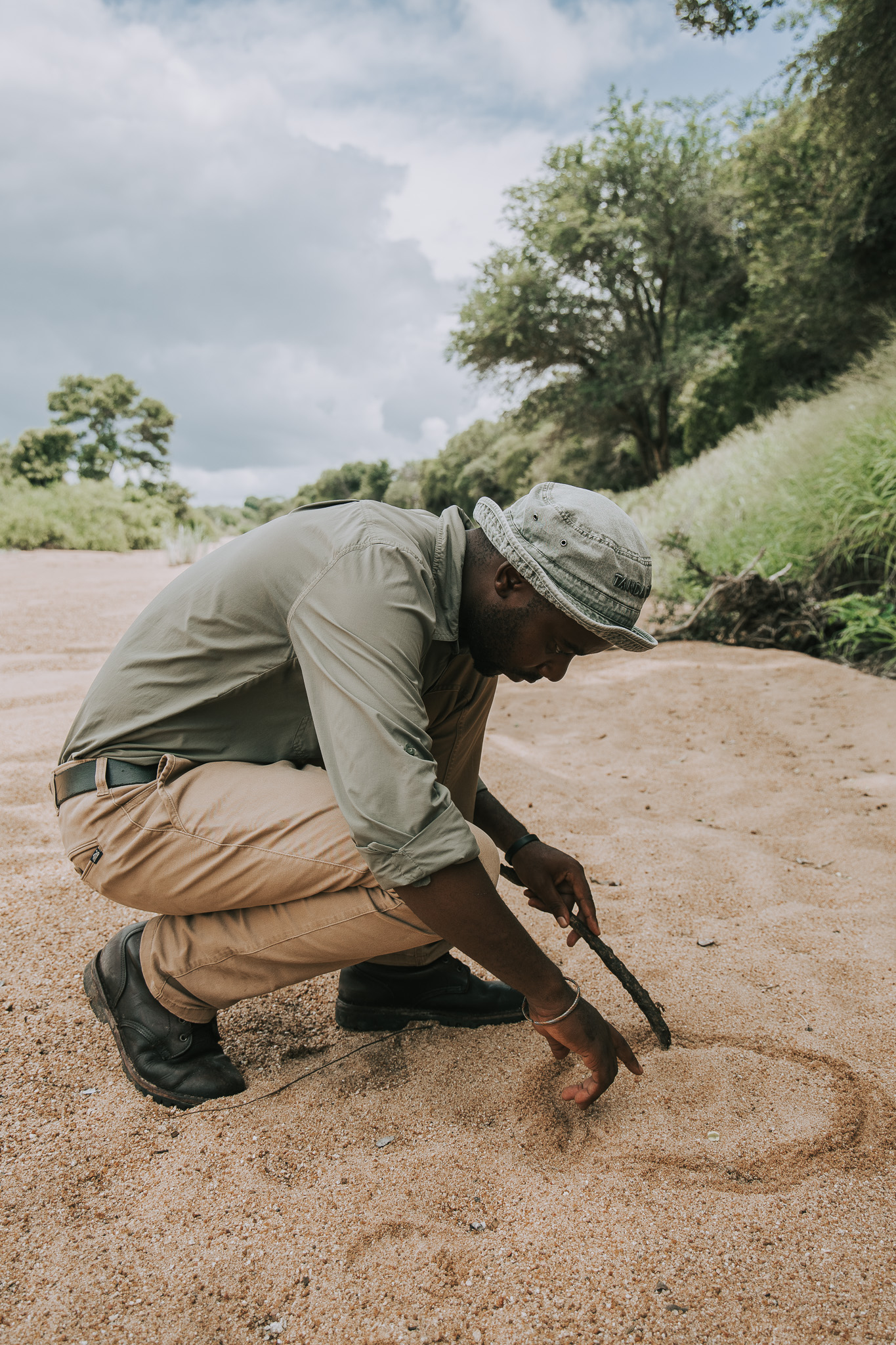 Skilled safari tracker analyzing footprints on a game drive in Timbavati, South Africa.