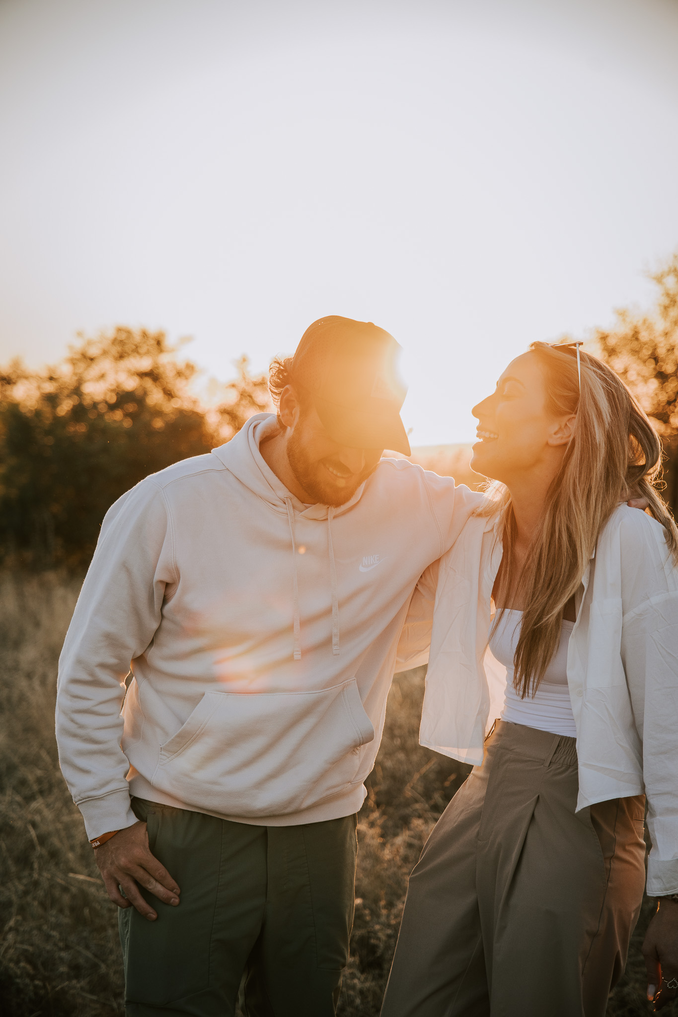 Couple laughing together in golden evening light on safari.