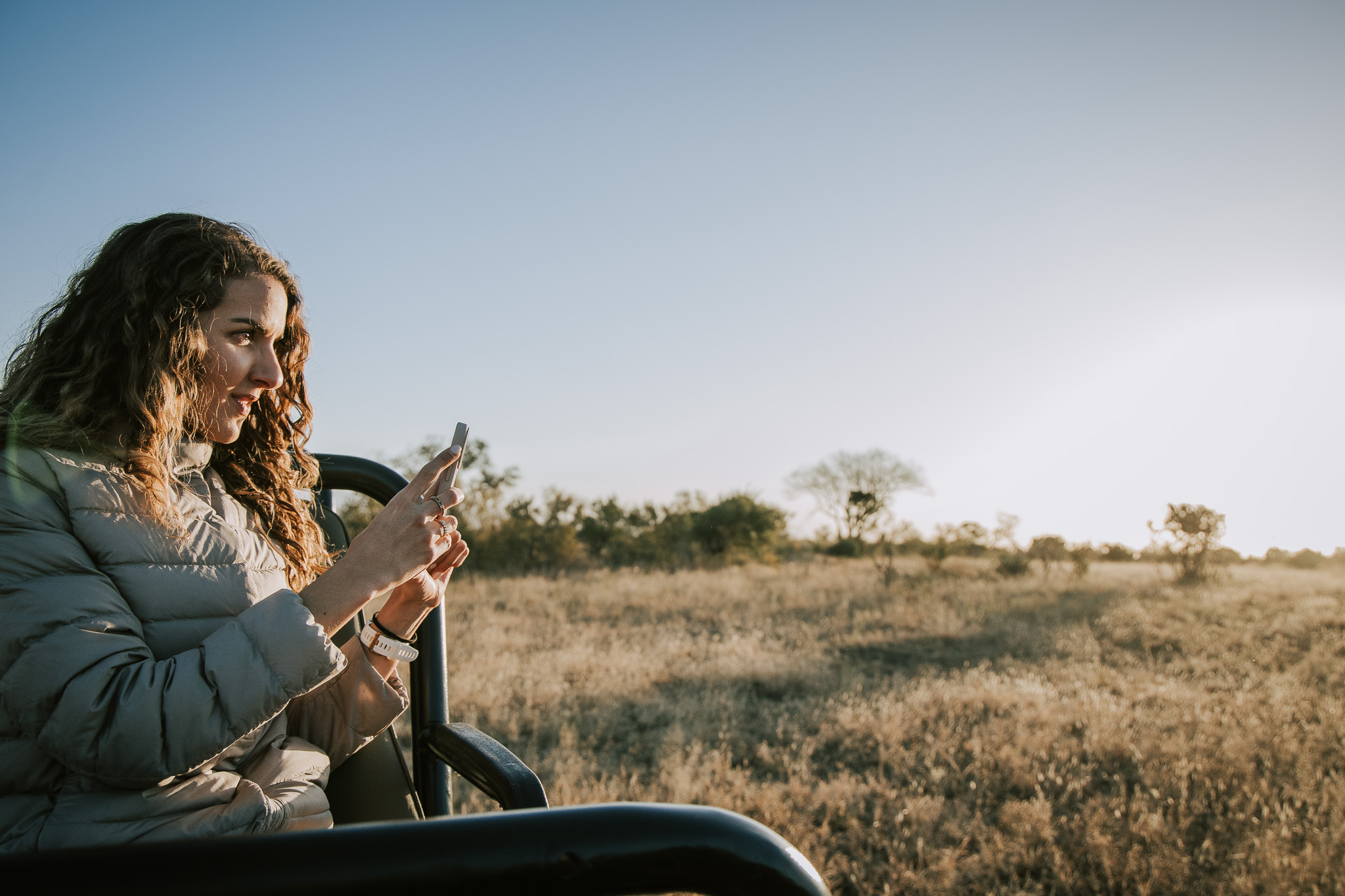 Woman photographing wildlife from a safari vehicle in Timbavati.