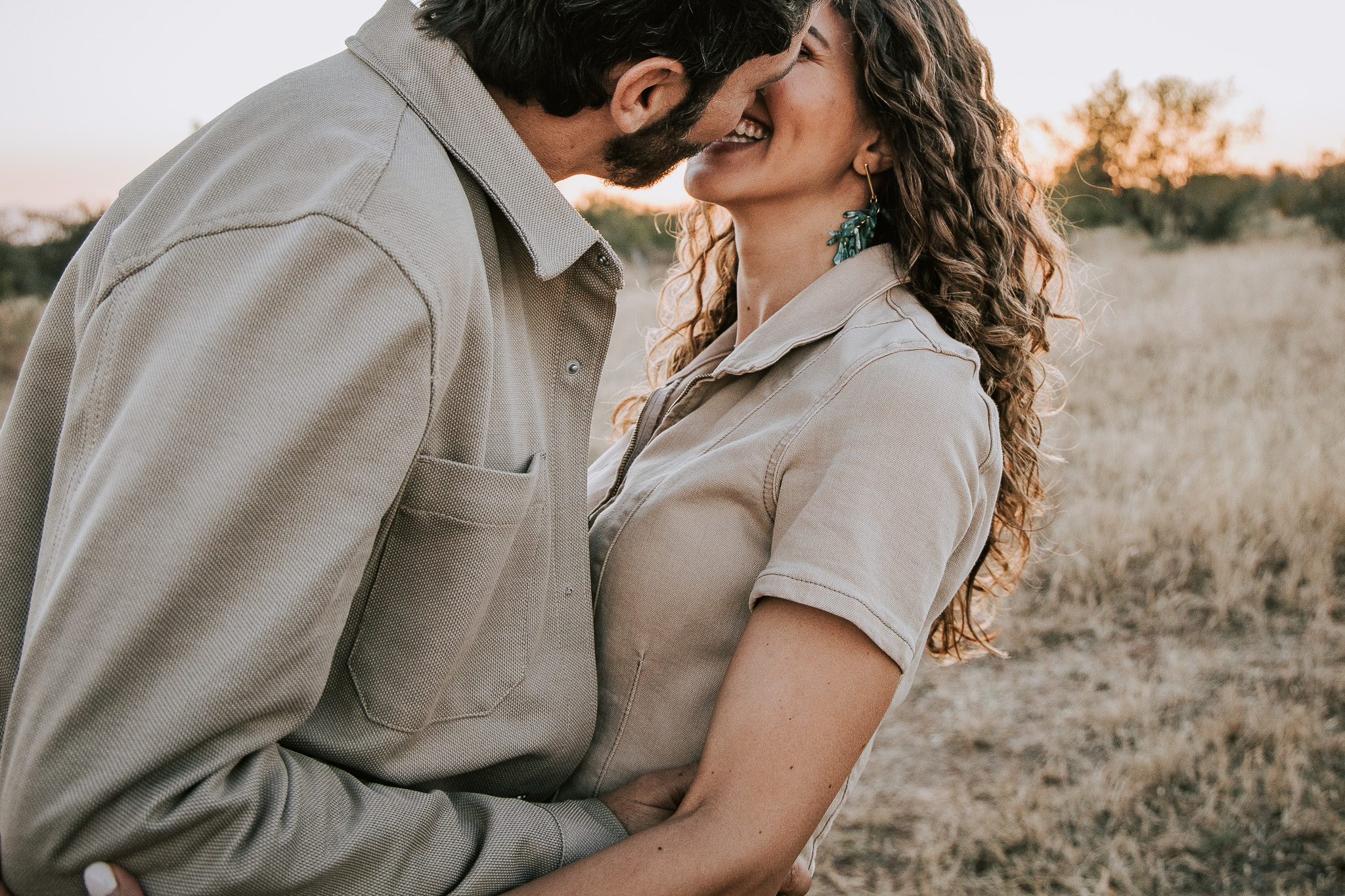 Couple sharing an intimate kiss in the golden evening light on safari.