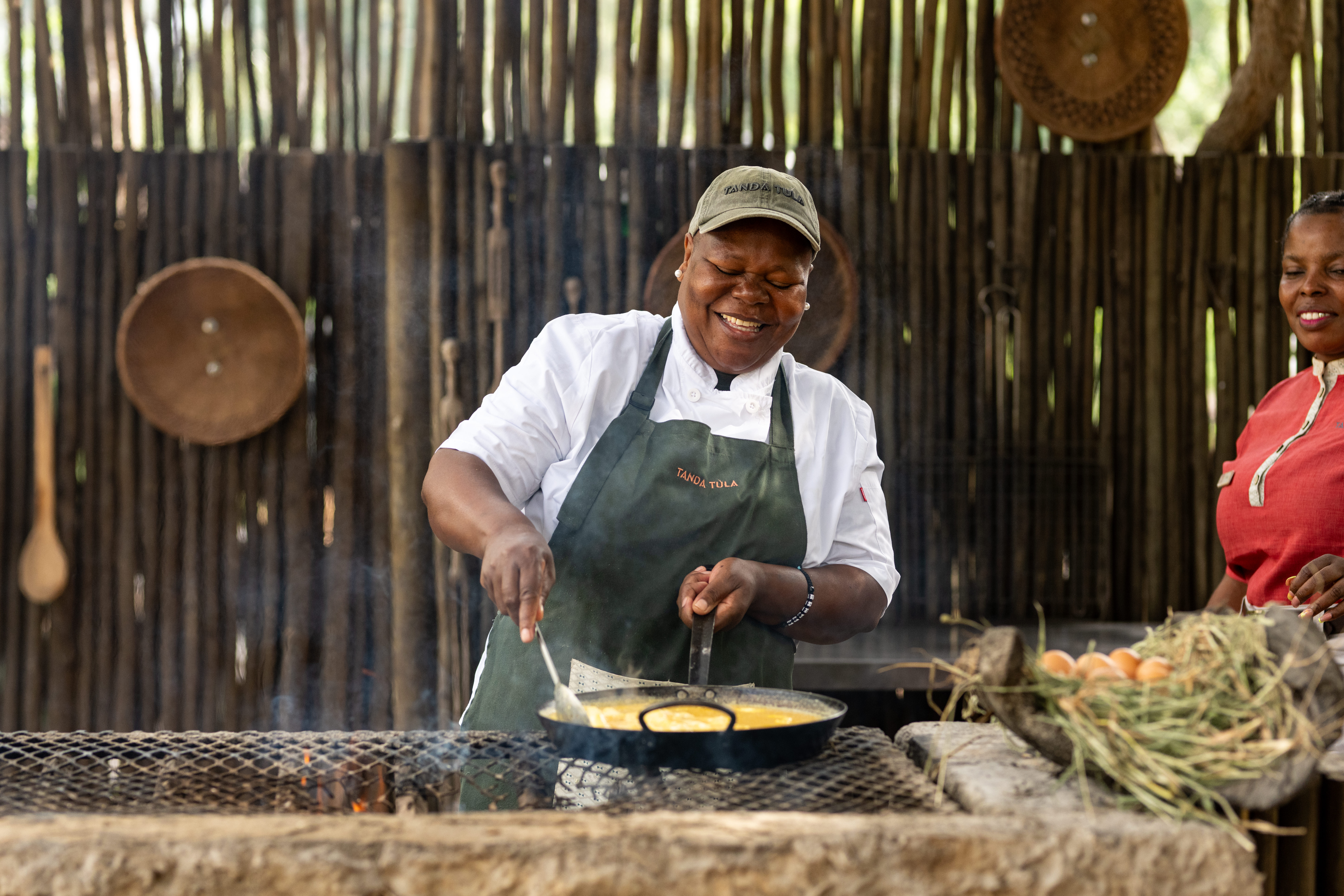 Beautifully set bush breakfast table with fresh fruit, coffee, and cooked-to-order dishes under open skies.