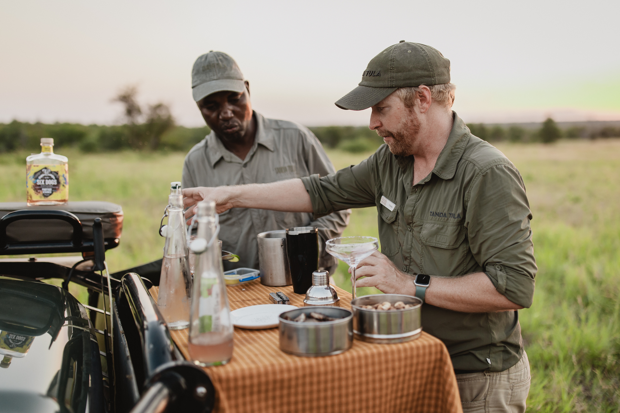 Safari guide preparing drinks on the game vehicle at sunset in the Timbavati.
