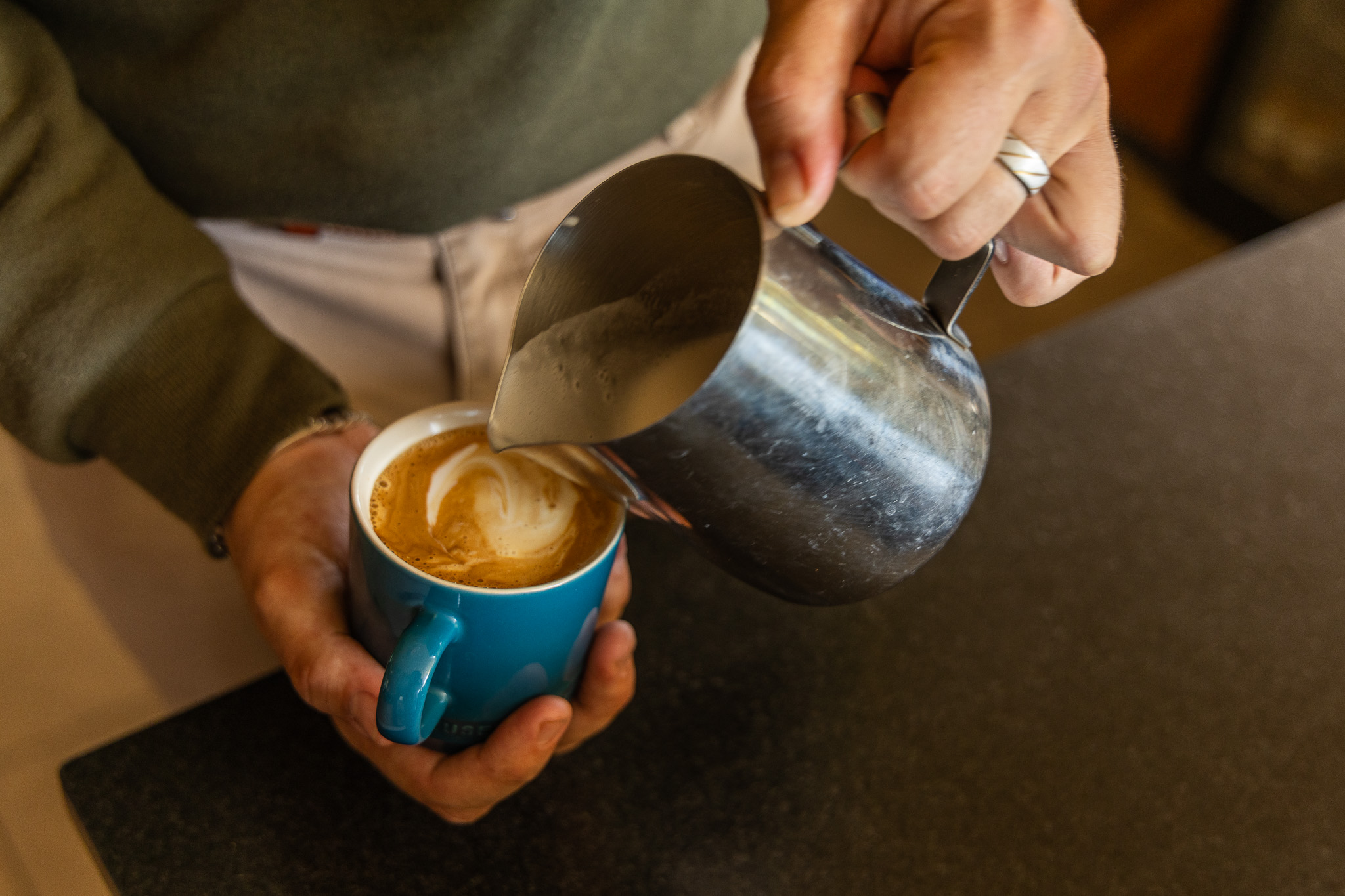A steaming cappuccino served in the bush at sunrise, with the wilderness beyond.