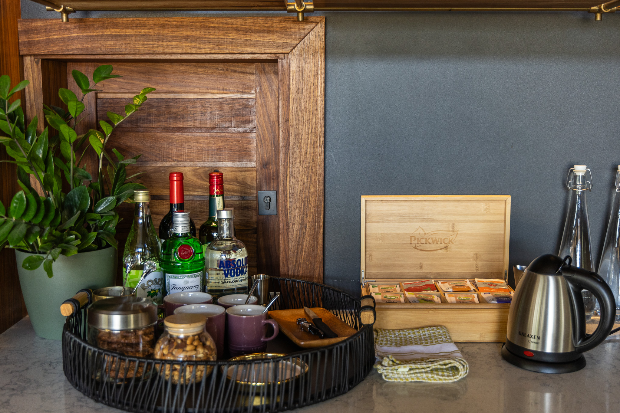 Luxury in-room snack and drinks setup including a mini bar, glassware, and treats.