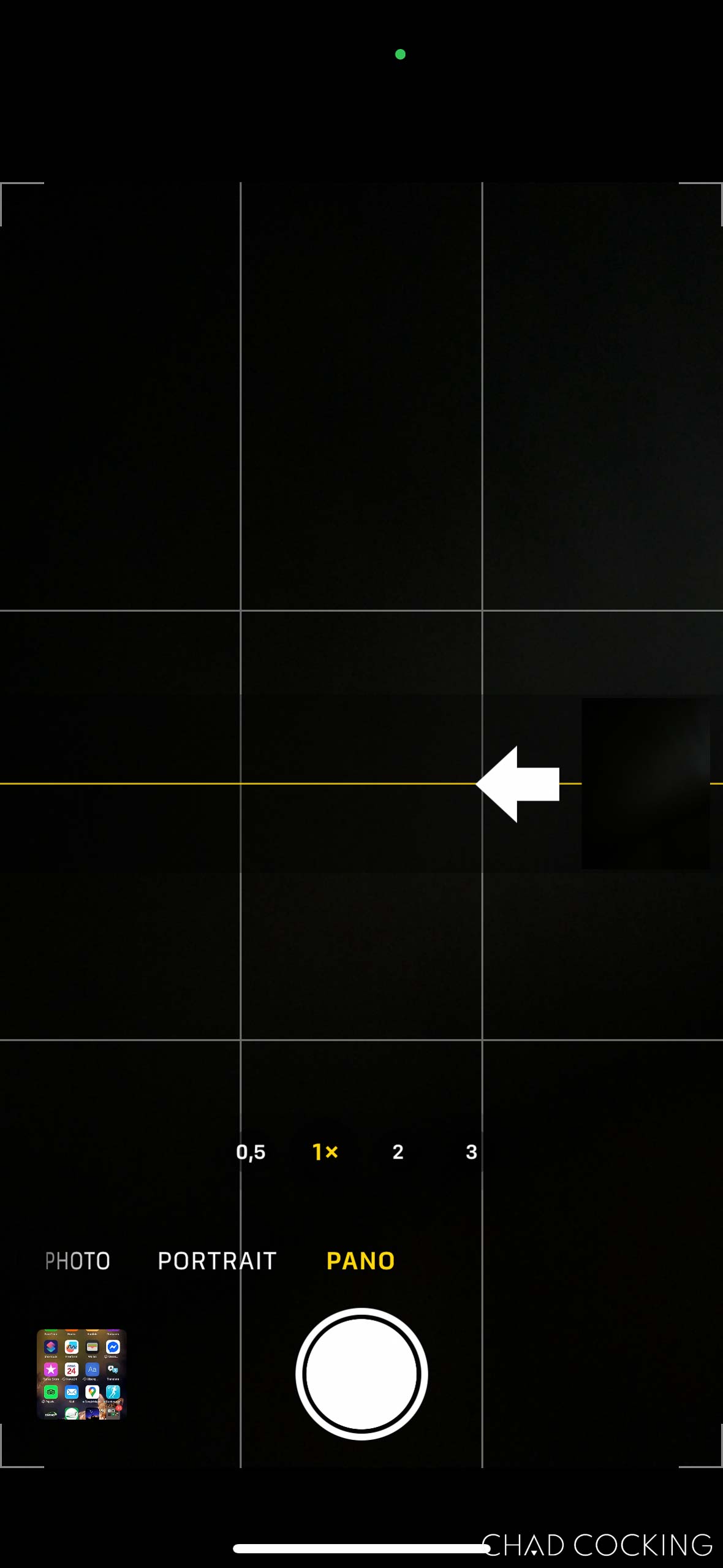 iPhone camera app in Panorama mode with the arrow pointing left to indicate a reversed sweep direction.